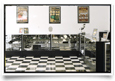 Vintage deli counter with checkered floor and posters.