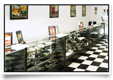 Display cases filled with glass items in a store with black and white checkered floor.