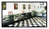 A room with black and white checkered flooring and display cases along the walls.