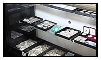 Organized trays filled with various gemstones in a display case.