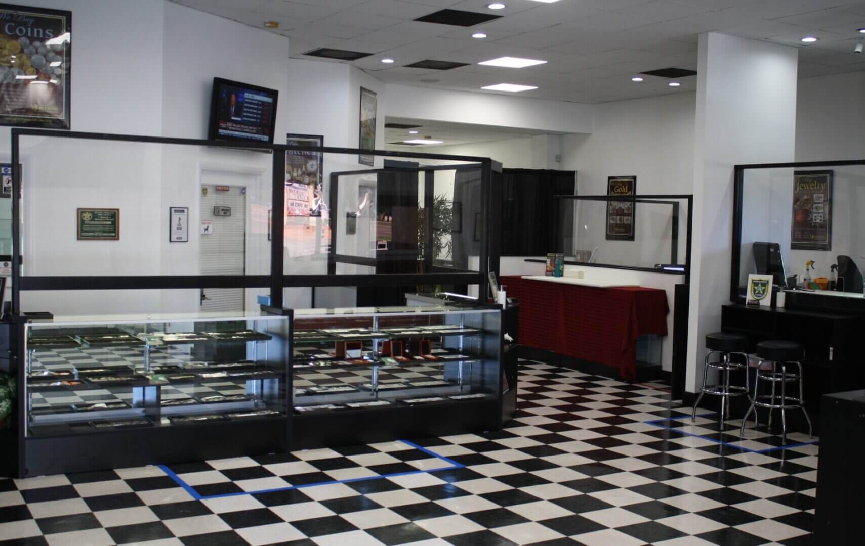 Empty store with checkered floor and glass display cases.
