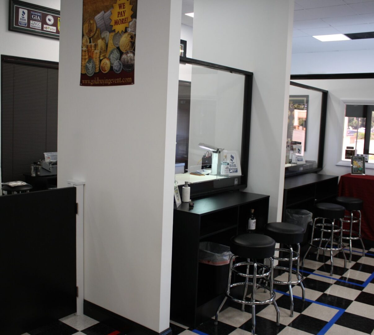 Modern barbershop interior with black and white checkered floor and multiple styling stations.